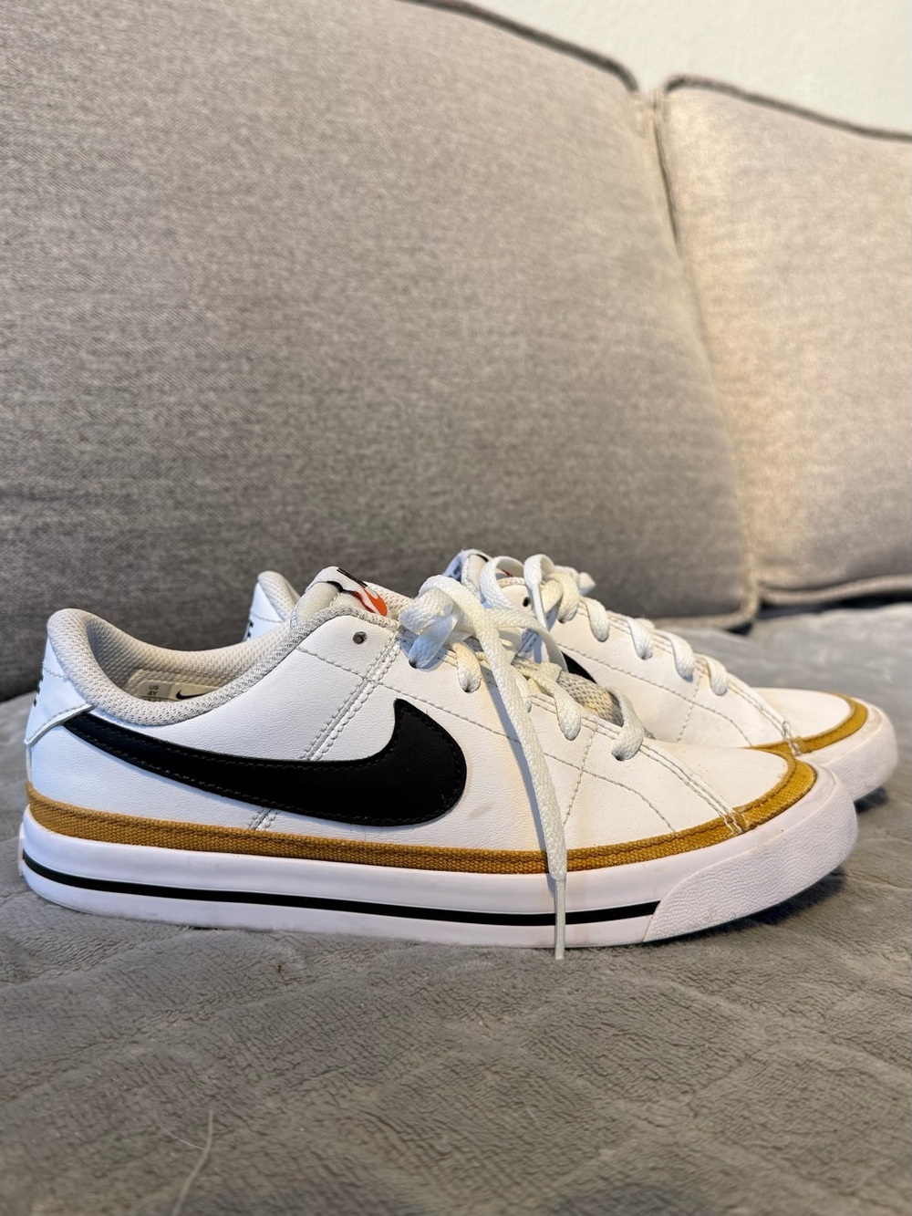 Nike White Low-Top Sneakers with Black Swoosh and Gold Trim